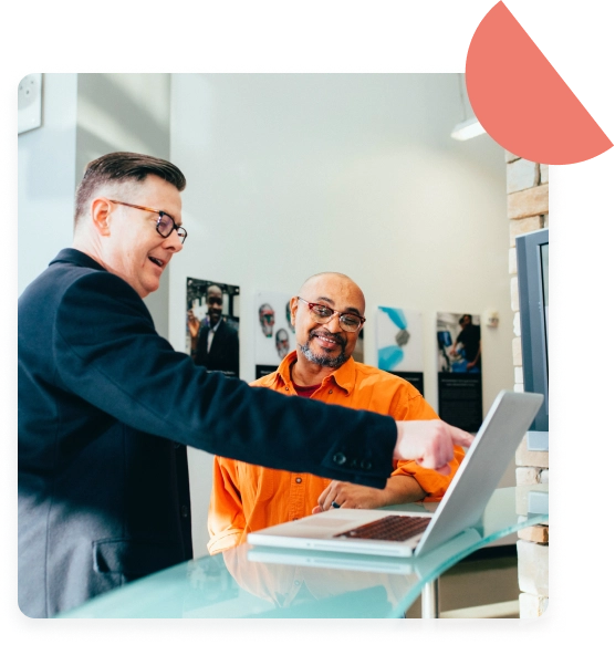 A man pointing a finger to the laptop, explaining something to another man